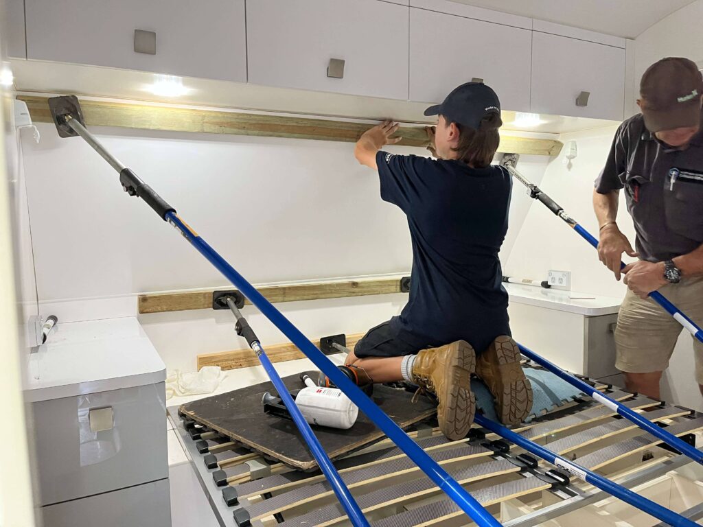 Northern Rivers Caravan Repairs technicians using support poles while upgrading the interior of a caravan.